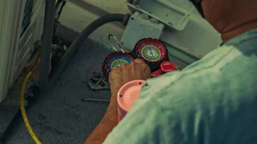 HVAC technician checking refrigerant gauges during a service call