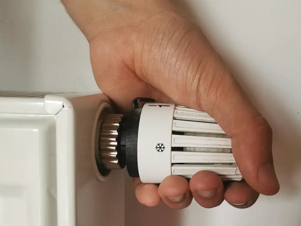 Hand adjusting a home radiator thermostat valve