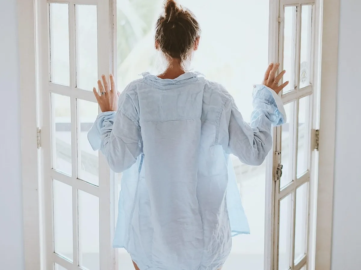 Person opening glass doors to ventilate a home with fresh air
