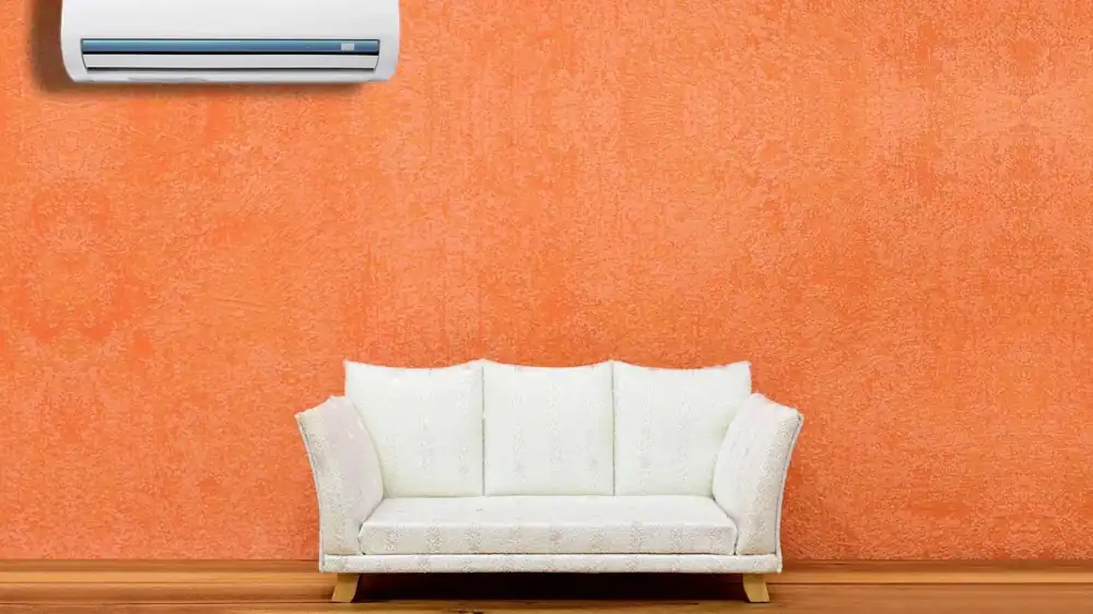 Wall-mounted air conditioner above a sofa in a home